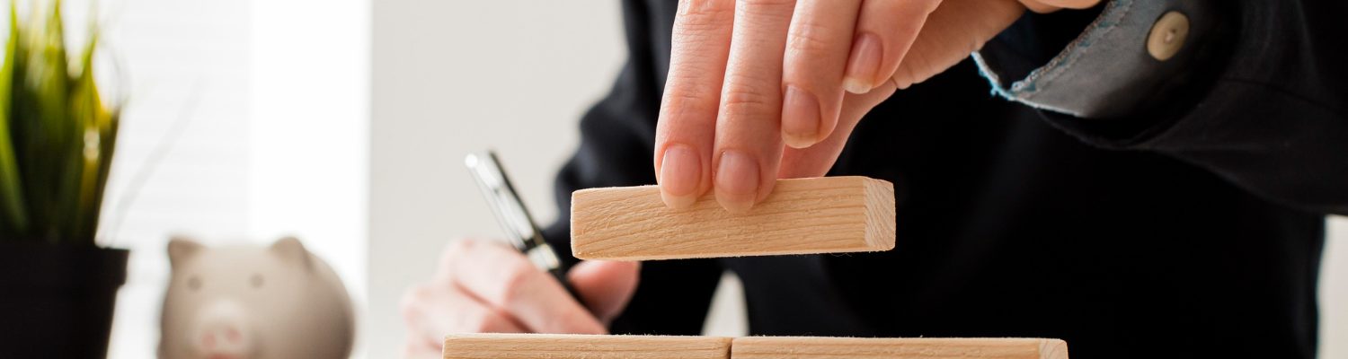 front-view-businessman-with-wooden-building-blocks Corporate Restructuring/ Merger and Amalgamation